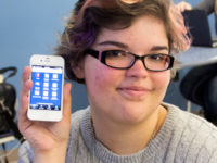 Liberal arts major Chani Pickett, 19, of Urbandale, holds up her phone with the DMACC app.