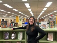 Librarian Emma Adams poses in the library, located in Building 6. Photo by Katie Hirth.