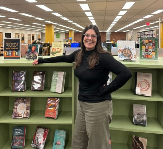 Librarian Emma Adams poses in the library, located in Building 6. Photo by Katie Hirth.